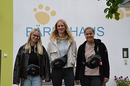 Bild zeigt duie drei Frauen vor der Kita Bärenhaus stehend mit den neuen Gürteltaschen vom DRK