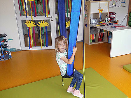 ein Kind schaukelt an Schaukelgurten
