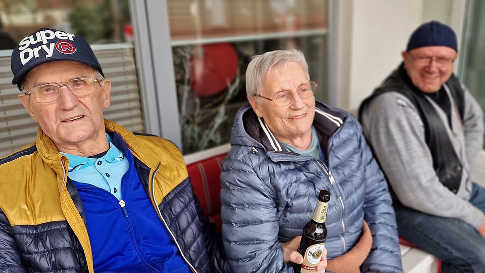 Bild zeigt 3 Bewohnende im gemütlichen Plausch miteinander