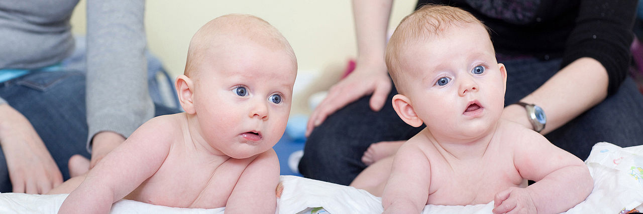 Bild zeigt zwei Babys auf Unterlagen liegend im Krabbelkreis