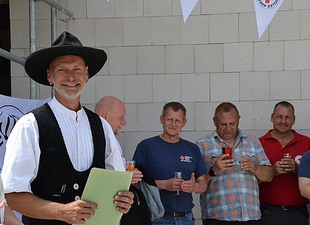 Bild zeigt Herrn Tobias Asse vorne links welcher den Richtspruch für das neue Gebäude vorträgt