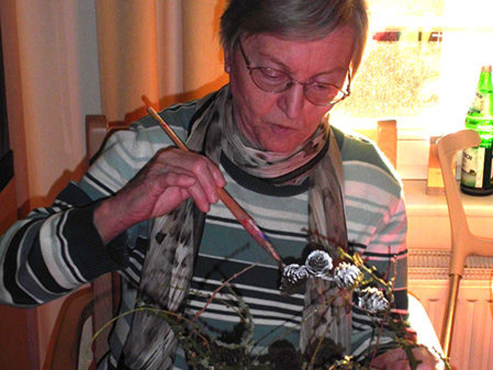 Bild zeigt eine Bewohnerin, welche mit Naturmaterialien gestaltet