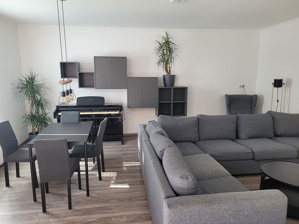 Bild zeigt einen Blick in den großen Wohngemeinschaftsraum mit Sitzlandschaft, Tisch und Stühlen