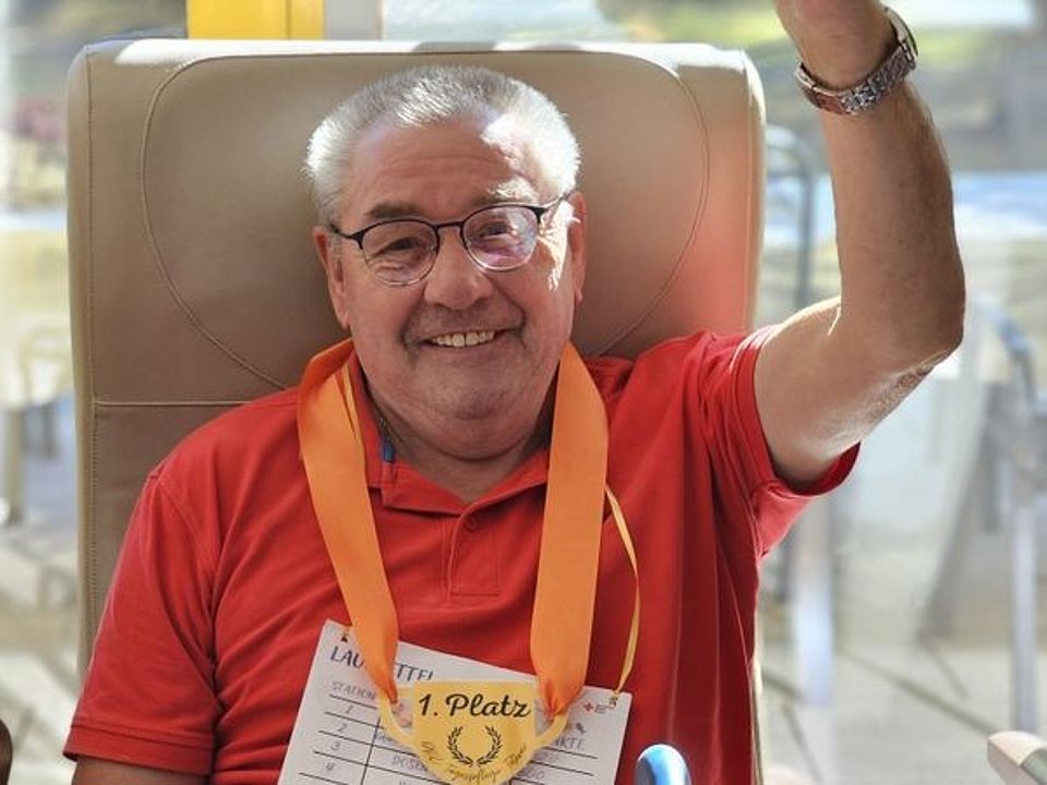 Bild zeigt einen Tagesgast nach einer sportlichen Aktivität bei der Siegerehrung mit einer Medaille