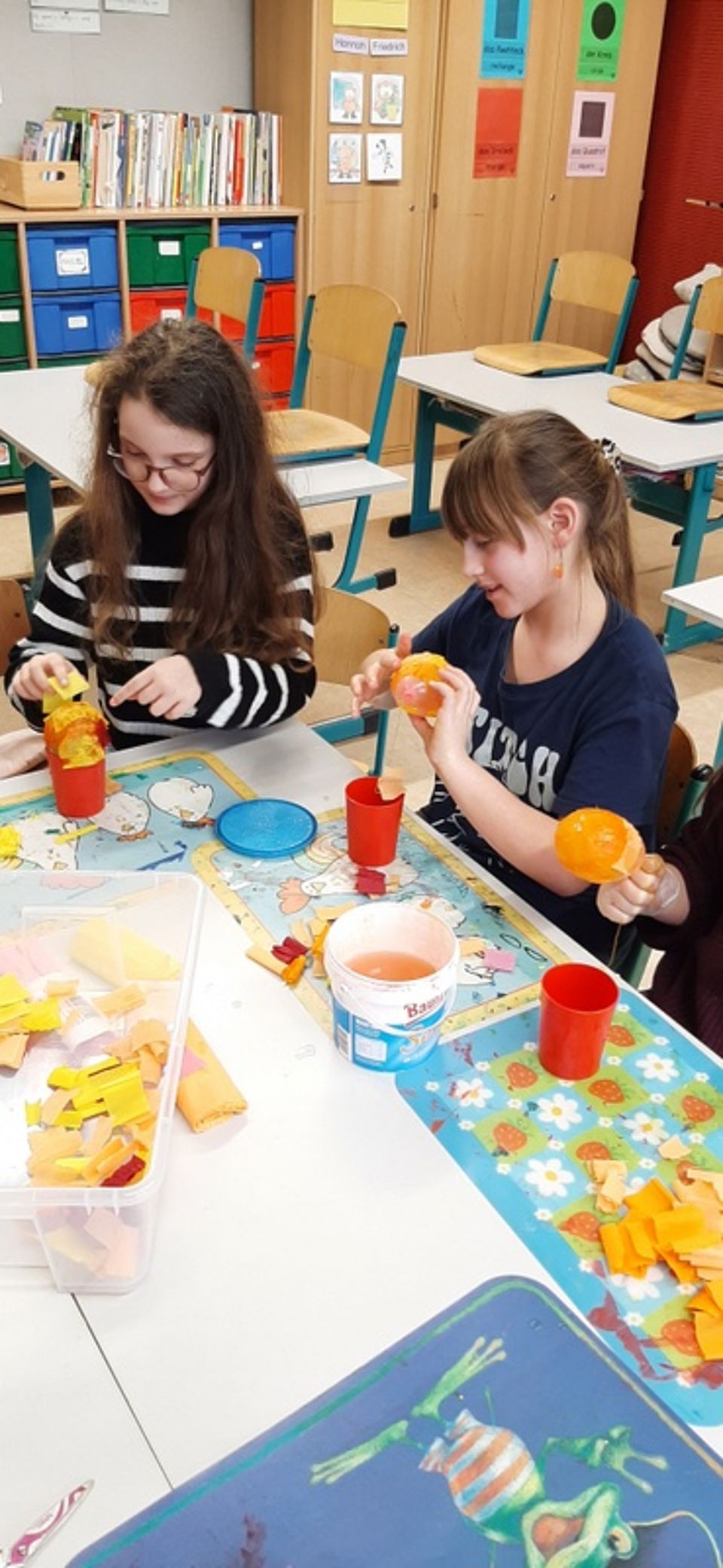 Bild zeigt zwei Mädchen beim einkleistern von Ballons
