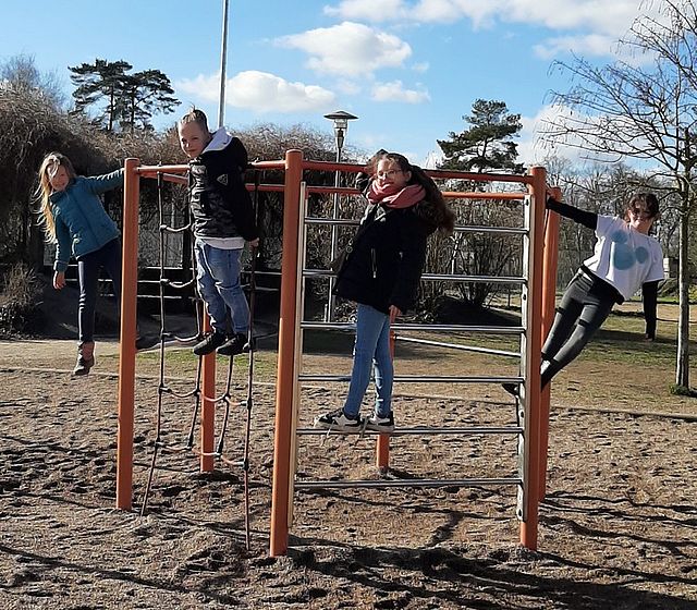 Bild zeigt 4 Kinder beim spielen auf einem Klettergerüst