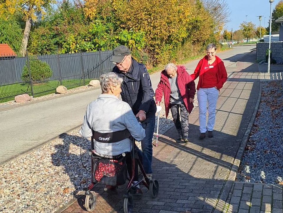 Bild zeigt mehrere Tagesgäste bei einem Spaziergang bei herrlich blauem Himmel und viel Sonne