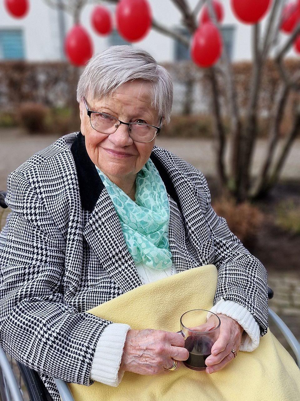 Bild zeigt eine Bewohnerin mit heißem Getränk