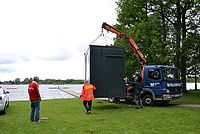 Bild zeigt das Abladen des Containers vom Tieflader