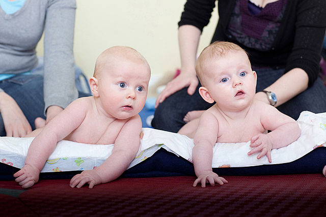 Bild zeigt zwei Babys auf Unterlagen liegend im Krabbelkreis