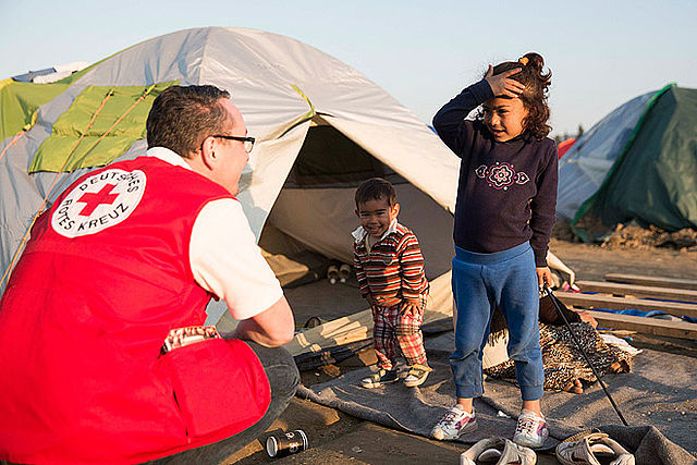 Bild zeigt Rotkreuzmitarbeiter mit hilfebedürftigen Kindern