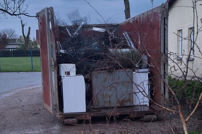 Bild zeigt einen Container, welcher schon recht gut mit gesammeltem Schrott gefüllt ist