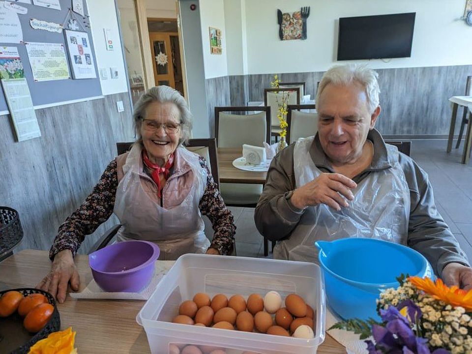 Bild zeigt zwei Tagesgäste, welche beim Eier abpellen für das Mittag helfen