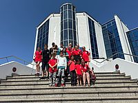 Bild zeigt die gesamte Teilnehmergruppe in einem Gruppenbild auf den Stufen vor dem Gebäude des HCC