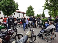 Bild zeigt den Platz wo die Fahrzeuge abgestellt sind und die Bewohner schauen sich die Fahrzeuge an