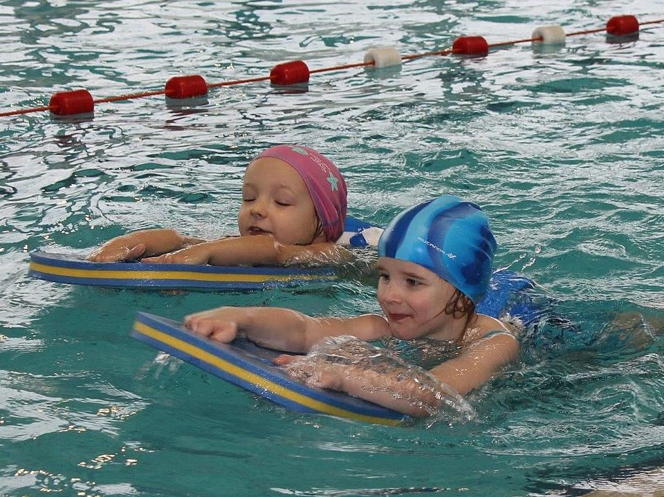 Bild zeigt zwei kleine Kinder beim Schwimmunterricht