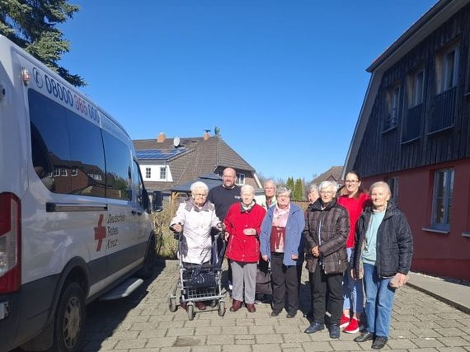 Bild zeigt eine Gruppe von Tagesgästen neben einem unserer Fahrdienst-Autos zu einem Gruppenbild aufgestellt. Die Fahrt wird in wenigen Minuten starten.