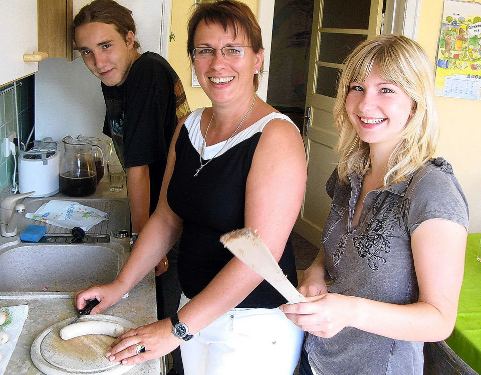 Nordkurier 21.12.2025 Bild 2 Bild zeigt die Leiterin des Kinder- und Jugendwohnhauses, Petra Wolter, (Mitte) in der Wohnküche mit zwei jugendlichen Bewohnern