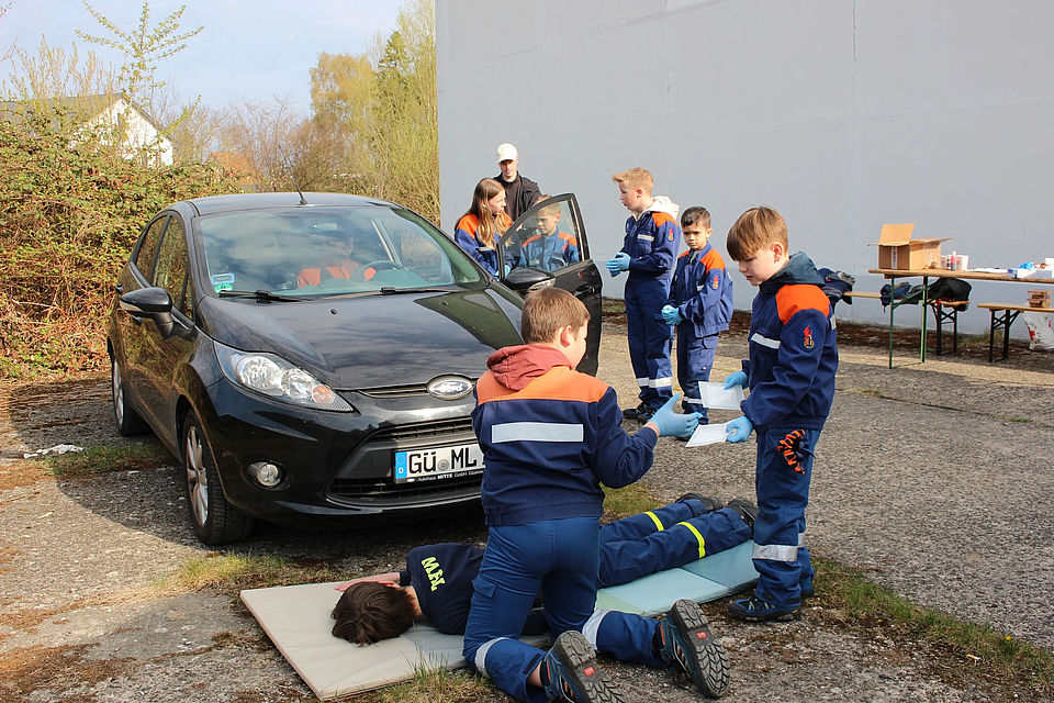 Bild zeigt die Gruppe der Kinderfeuerwehr Schwaan die einen Verletzten bei einem simulierten Unfall versorgen.
