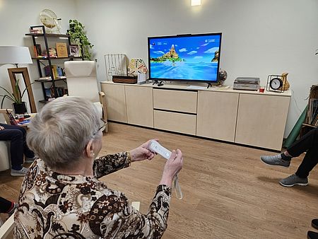 Bild zeigt einen Tagesgast beim spielen mit der Wii Konsole 