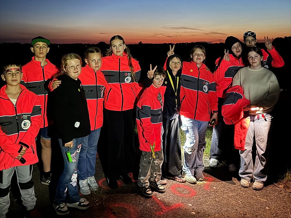 Bild zeigt die Teilnehmer des Camps bei der Nachtwanderung als Gruppe stehend für ein Gruppenfoto