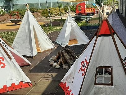Bild zeigt eine Fläche mit 5 Tipi ähnlichen Zelten. Die Zelte sind mit Ornamenten bemalt.