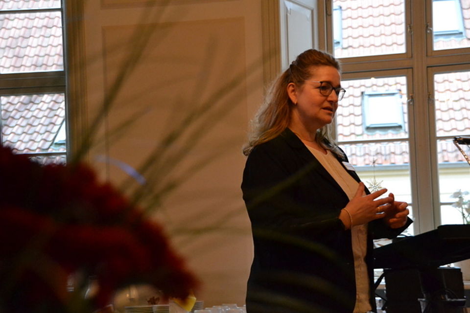 Weiterbildung Bild 2 Bild zeigt Frau Cornelia Heidenreich, Bereichsleiterin der ambulanten Pflege, an einem Redepult stehend und zu ihren Mitarbeitenden spricht.