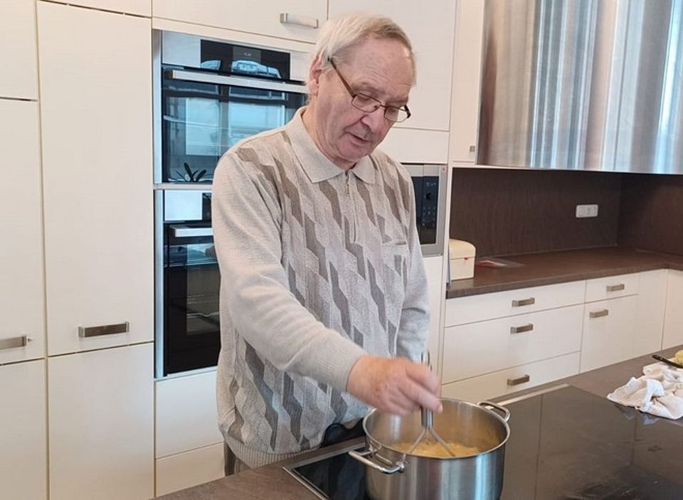 Bild zeigt einen Tagesgast bei Apfelmus kochen an der großen Kochinsel