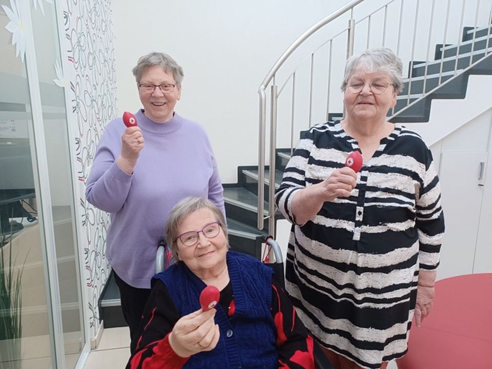 Bild zeigt 3 Besucherinnen der Tagespflege. Jede hat einen, mit Sand gefüllten nicht aufgeblasenen Luftballon in der Hand. Damit wird dann der Weitwurf durchgeführt