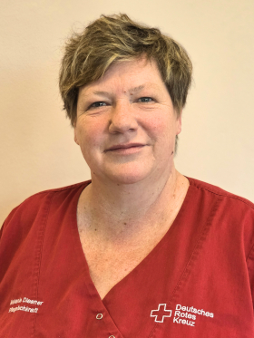 Melanie Diesner Bild zeigt eine Porträtaufnahme von Frau Melanie Diesner. Sie trägt einen roten Kasak mit dem Schriftzug Deutsches Rotes Kreuz auf der linken Seite und rechts steht ihr Name und die Funktion