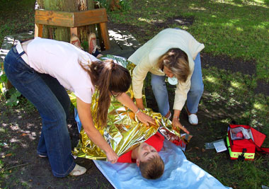 das Bild zeigt zwei Schüler, die sich übungsmäßig um einen Verletzten kümmerneinen