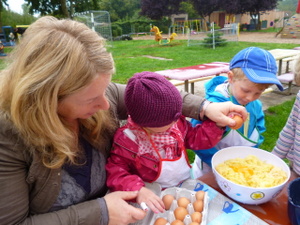 Kinder schlagen Eier in eine Schüssel