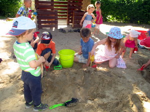 Kinder spielen in einem großen Kies-Sand-Haufen