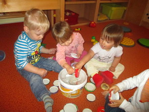 Gruppe von Kleinkindern beim spielen mit alltäglichen Materialien