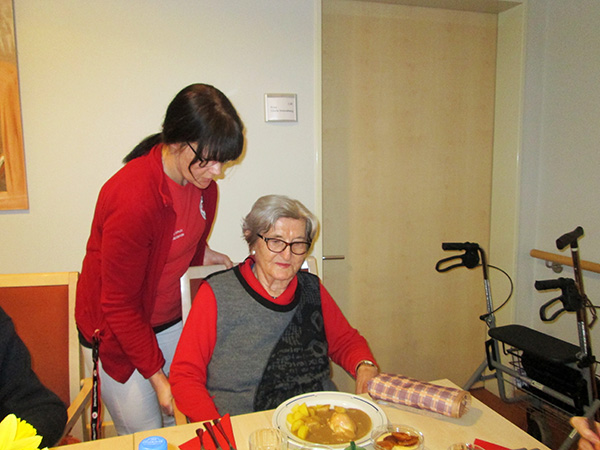 Auszubildende mit Bewohnerin beim Mittagessen