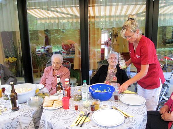grillen auf der Terasse Bewohner und Personal auf der Terrasse am Tisch, eingedeckt mit Essen