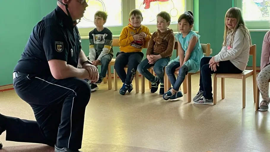 Bild zeigt den Polizeihauptmeister in der Runde mit den Kindern