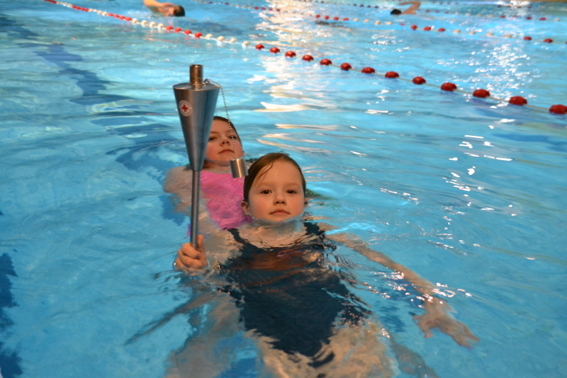 Bild zeigt Pia und Enni mit der Fackel im großen Schwimmbecken