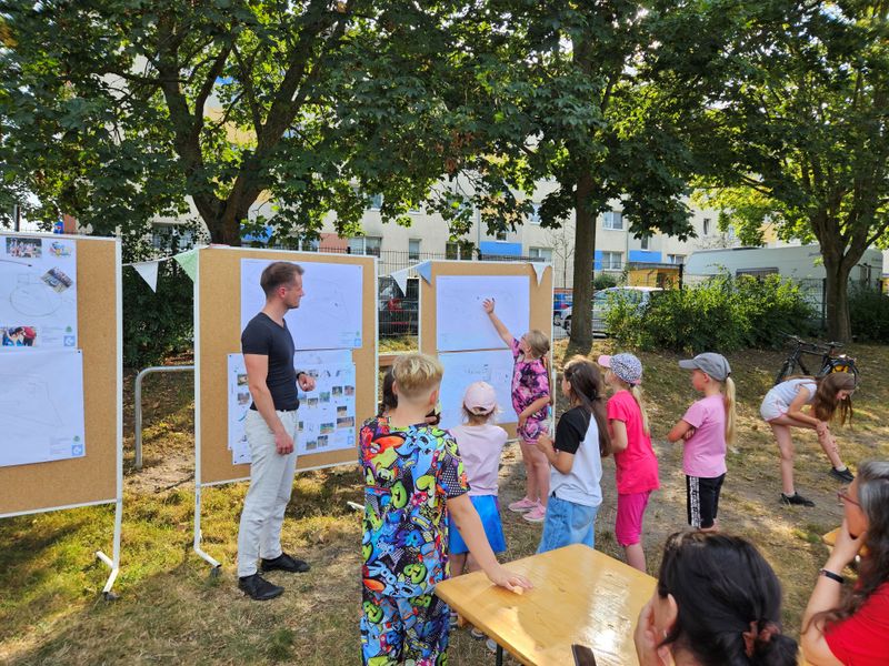 Bild zeigt Kinder die ihre Ideen an eine Aufstellwand pinnen