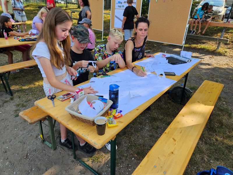 Bild zeigt Kinder an Tischen, die das neue Aussehen des Spielplatzen planen 