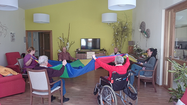 Gruppe von Senioren spielt mit einem Schwungtuch