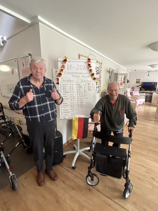 Bild zeigt zwei Fußball begeisterte Tagesgäste vor der Tipptafel zur EM 2024 auf der jeder den Endstand des Spieles Deutschland vs Schottland tippen konnte