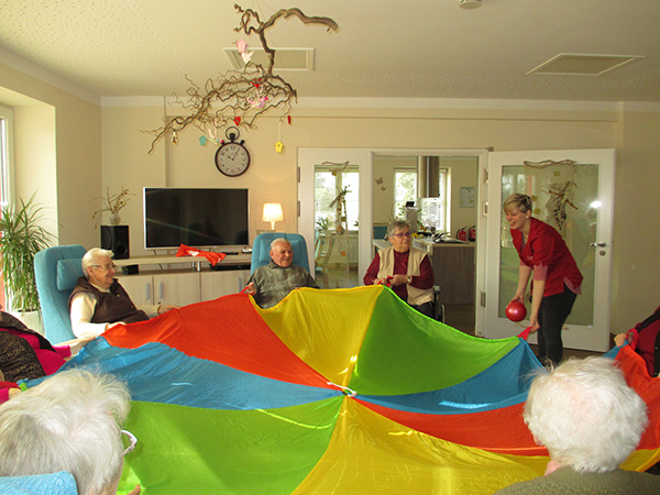 Gruppe von Senioren spielt mit einem Schwungtuch