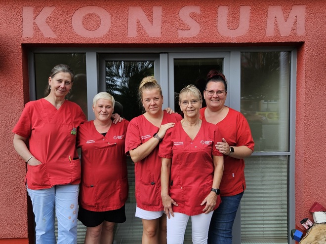 Bild zeigt die 5 Teammitglieder der Tagespflege in Lalendorf. Von links nach rechts Das Team der DRK Tagespflege in Lalendorf. v.l.n.r. Ramona Lehmkuhl, Dana Gehrt, Kathrin Krethlow, Kerstin Kientopf und Nicole Kauf. Sie stehen vor dem Haupteingang über dem der alte Schriftzung "KONSUM" zu sehen ist, da das Gebäude in früheren Zeiten der Dorfkonsum war.