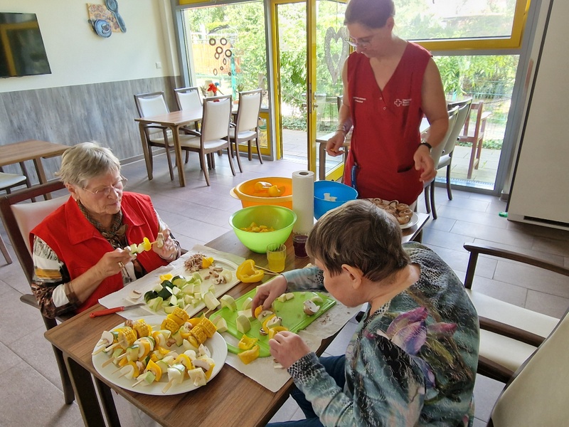Bild zeigt Senioren am Tisch beim putzen und schnibbeln von Gemüse