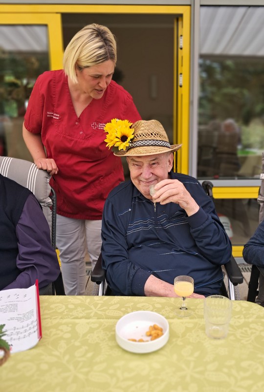Bild zeigt einen Tagesgast auf der Terrasse am Tisch sitzend mit einem Getränk und Knabberzeug
