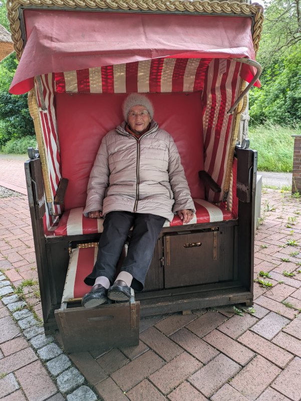 Bild zeigt eine Frau am Burgwall in einem Strandkorb sitzend
