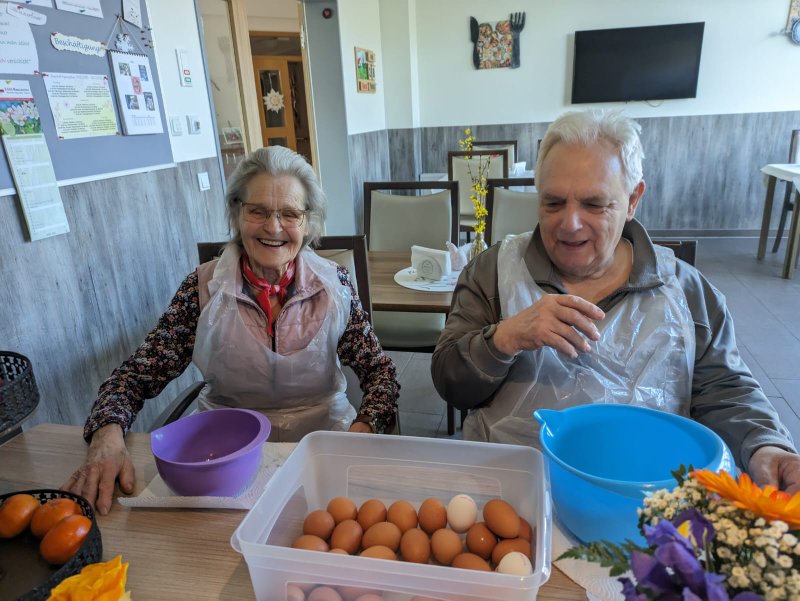Bild zeigt zwei Tagesgäste, welche beim Eier abpellen für das Mittag helfen