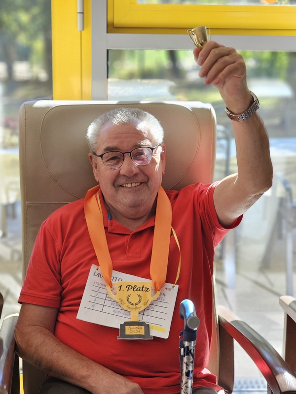 Bild zeigt einen Tagesgast nach einer sportlichen Aktivität bei der Siegerehrung mit einer Medaille